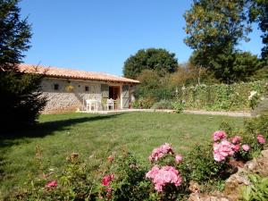 a house in a garden with pink flowers at Gîte de la vacherie in Port de Salles