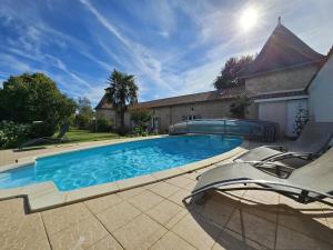 a swimming pool with chairs and a house at Gîte de la vacherie in Port de Salles