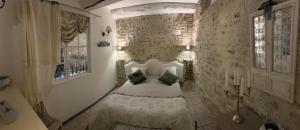 a bedroom with a bed in a stone wall at Gîte "Le Bleu D'Orage" Dans un Domaine de 7ha Au Calme in Vimoutiers +30 photos