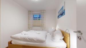 a bedroom with a white bed with a window at strandnahe FeWo mit 2 Schlafzimmern und Terrasse oder Balkon, Caspar David, Binz in Binz
