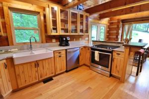 a kitchen with wooden cabinets and a sink and a stove at The Highland in Cherokee