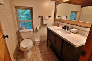a bathroom with a toilet and a sink and a mirror at The Highland in Cherokee +30 photos