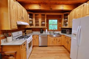 a kitchen with wooden cabinets and a white refrigerator at The Ridge in Cherokee