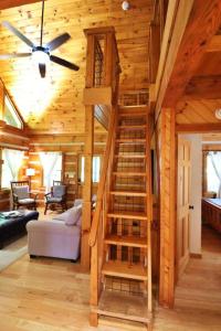 a wooden cabin with a spiral staircase in a living room at The Ridge in Cherokee