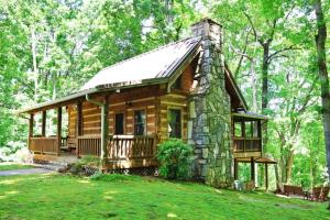 a log cabin in the woods with a stone chimney at The Ridge in Cherokee