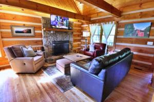 a living room with leather furniture and a fireplace at The Oakes in Cherokee