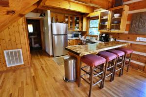 a kitchen with a counter with a refrigerator and bar stools at The Oakes in Cherokee