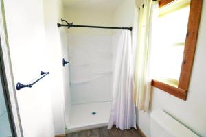 a bathroom with a shower with a shower curtain at The Oakes in Cherokee