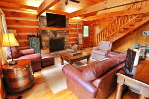a living room with leather furniture and a fireplace at The Hilltop in Cherokee