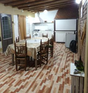 a dining room with a table and chairs and a kitchen at El Volcán in Tupungato