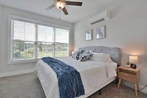a bedroom with a bed with a ceiling fan and a window at Rooftop Balcony with River View in SoKnox in Knoxville