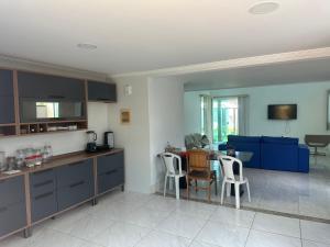 a kitchen and living room with a table and chairs at Casa de Praia 6 quartos e 4 suítes! in Valença