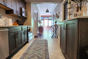 a kitchen with green cabinets and a rug on the floor at The Nama Retreat 201 - Renovated Downtown Loft near Gay St | Walk Everywhere in Knoxville