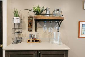 a counter with glasses and bottles on a shelf at The Nama Retreat 201 - Renovated Downtown Loft near Gay St | Walk Everywhere in Knoxville +12 photos