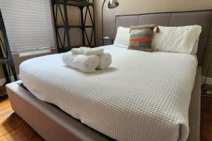 a bed with two towels sitting on top of it at The Nama Retreat 201 - Renovated Downtown Loft near Gay St | Walk Everywhere in Knoxville