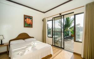 1 dormitorio con 1 cama y puerta corredera de cristal en Turtle Inn Resort, en Boracay