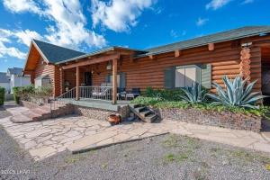 a log home with a porch and a patio at Kingman Cabin in Kingman