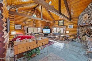 a living room with a fireplace in a log cabin at Kingman Cabin in Kingman