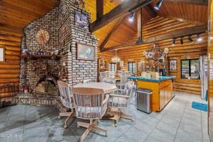 a dining room with a table and a stone fireplace at Kingman Cabin in Kingman