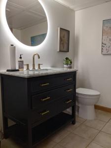 a bathroom with a sink and a toilet and a mirror at Lawrenceville Escape in Lawrenceville +6 photos
