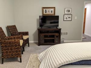 a bedroom with a bed and a tv and a chair at Lawrenceville Escape in Lawrenceville