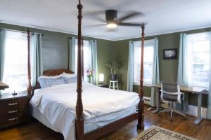 a bedroom with a bed with a ceiling fan at The Garden House in Saco