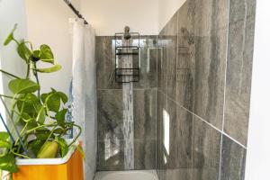 a bathroom with a shower with a plant at The Garden House in Saco +62 photos