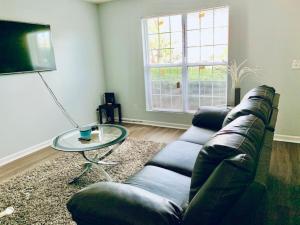 a living room with a couch and a glass table at Covington Station Escape in Lithonia