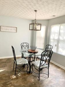 a dining room with a glass table and chairs at Covington Station Escape in Lithonia