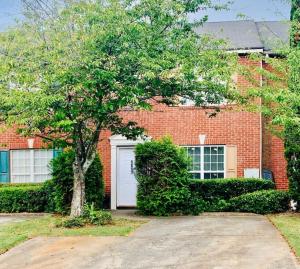 a brick house with a white door and a tree at Covington Station Escape in Lithonia