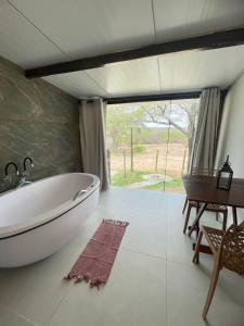 a bathroom with a tub and a table and a desk at Suítes Domo do Matto in Garanhuns +73 photos