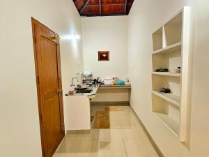 a small kitchen with a sink and a counter at Mamoksha Riverdale in Padinjarathara