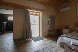 a bedroom with a bed and a large window at Le Petit courault in Pamproux