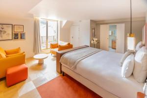 a bedroom with a large bed and a living room at Hôtel Pilgrim in Paris