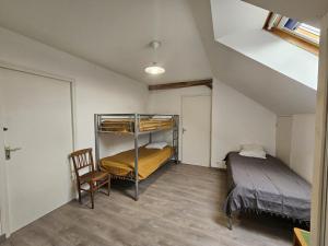 a bedroom with two bunk beds and a chair at Le pin de la tour in Sossais