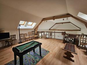 a room with a pool table in the middle of a room at Le pin de la tour in Sossais
