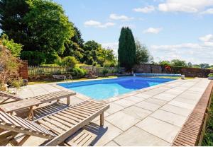 a swimming pool with two loungers next to at The Retreat in Redlynch