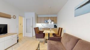 a living room and kitchen with a couch and a table at Appartementhaus Binzer Sterne 09 in Binz