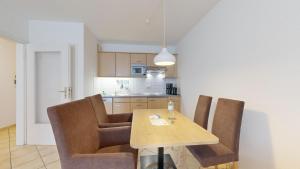 a kitchen with a wooden table and chairs in a room at Appartementhaus Binzer Sterne 09 in Binz +16 photos