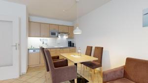 a kitchen and dining room with a table and chairs at Appartementhaus Binzer Sterne 09 in Binz