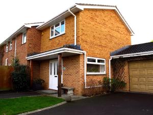 a brick house with a white door and a garage at Mahe - Lee on the Solent in Lee-on-the-Solent