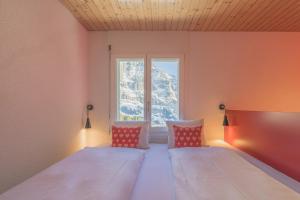 a bedroom with two beds and a window at Alpinhotel Bort in Grindelwald