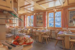 a large room with tables and chairs and a bakery at Alpinhotel Bort in Grindelwald