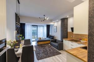 a kitchen and living room with a couch and a table at FRANKO APARTAMENTS - Hanza Tower in Szczecin