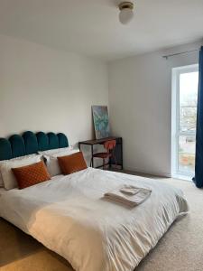 a bedroom with a large bed with a blue headboard at Prime Location - Apt - Stay 4 - Lakeside - Parking in Grays Thurrock