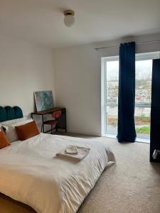 a bedroom with a large bed and a large window at Prime Location - Apt - Stay 4 - Lakeside - Parking in Grays Thurrock