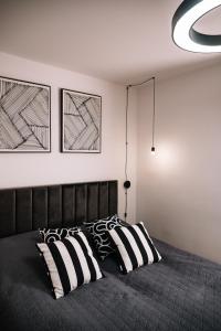 a bedroom with a bed with black and white pillows at Zakątek Lipowy Most in Lipowy Most
