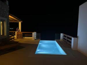 a room with a blue pool on a building at night at Villa Kalydna in Kalymnos