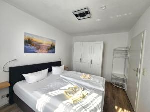 a bedroom with a bed with yellow towels on it at Appartementhaus Binzer Sterne 11 in Binz