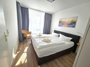 a hotel room with a bed with towels on it at Appartementhaus Binzer Sterne 11 in Binz +11 photos